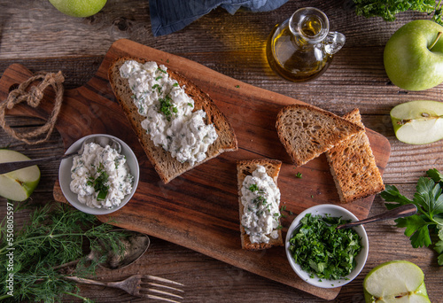 Fototapeta Naklejka Na Ścianę i Meble -  Roasted rye bread with cottage cheese salad on wooden table. Flat lay