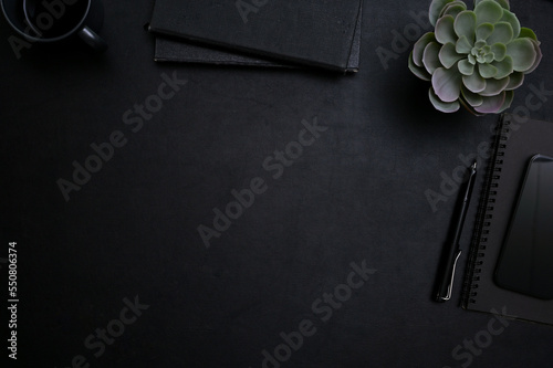 Top view, Black workspace with copy space for display your text, pen, notebooks and decor plant.