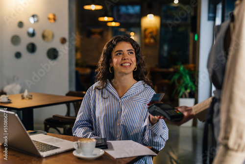 Foto A satisfied customer pays her bill