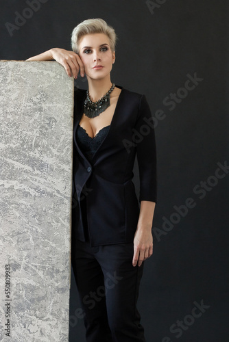 Beautiful woman in black standing near easel