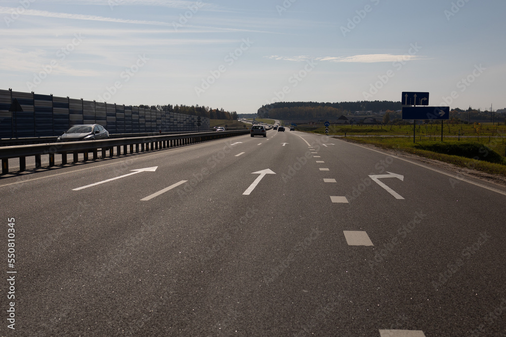Fototapeta premium Highway wide road, transport and blue sky with clouds on a summer day