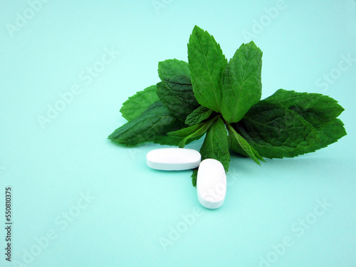 Herbal Medicine.Organic pills with mint leaves on the background photo