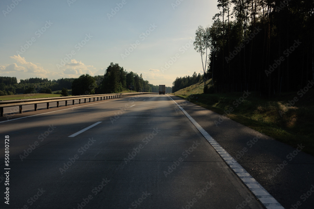 Fototapeta premium Highway wide road, transport and blue sky with clouds on a summer day