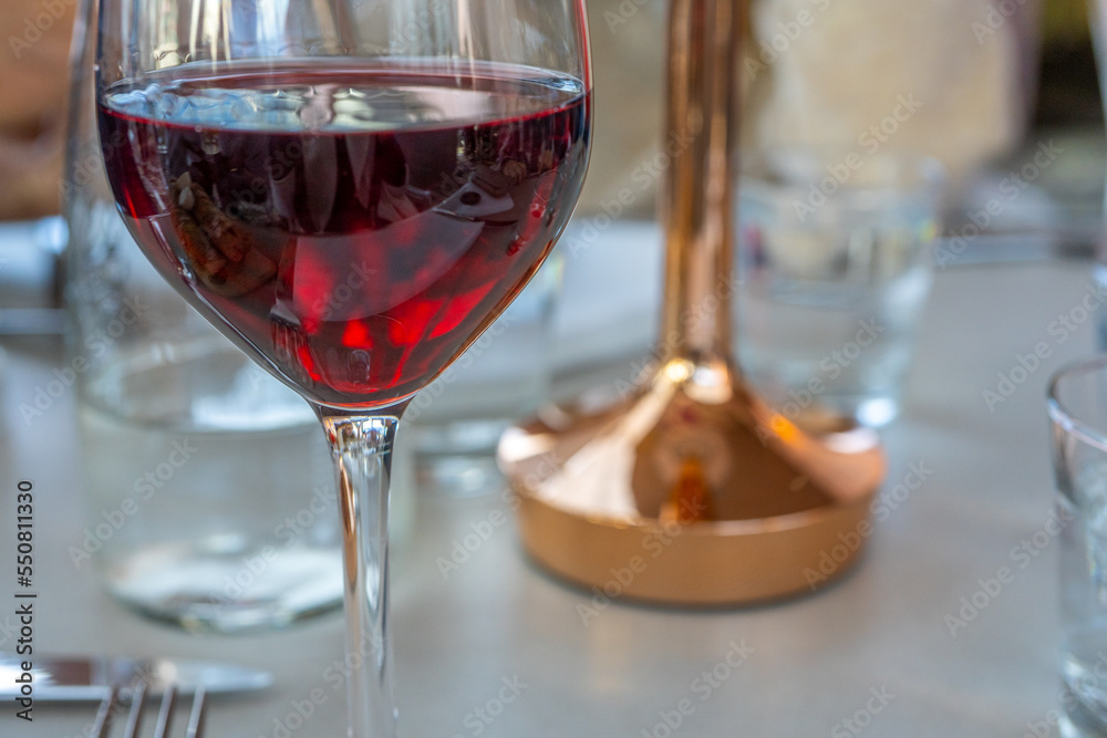 Red wine glass on a table. Dark and warm colors. High quality photo