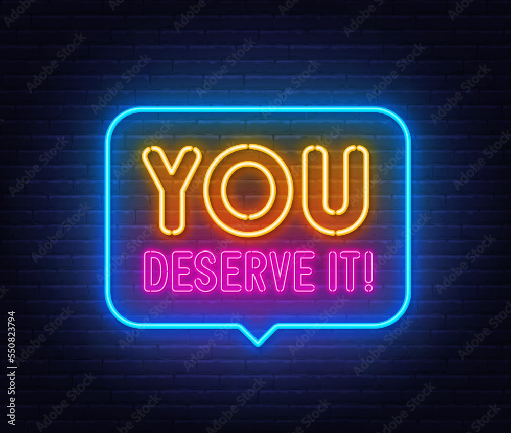 You Deserve It neon sign in the speech bubble on brick wall background. You Deserve It neon sign in the speech bubble on brick wall background.