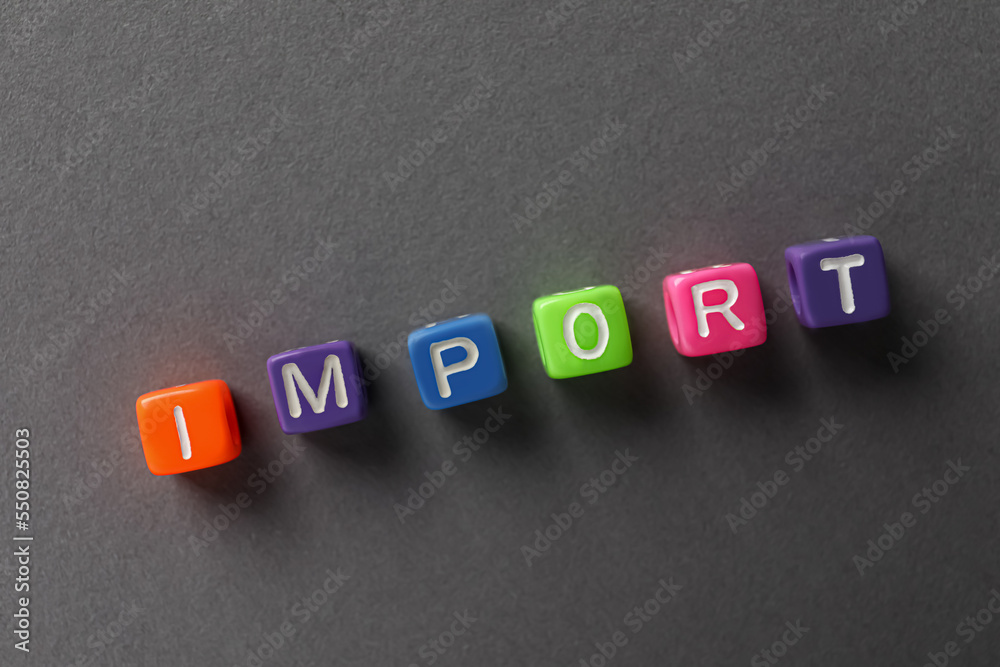Obraz premium Word Import made of colorful cubes on dark grey background, flat lay