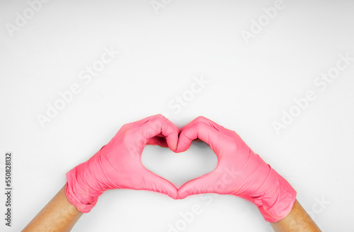 Hands in heart-shaped medecine gloves color viva magenta