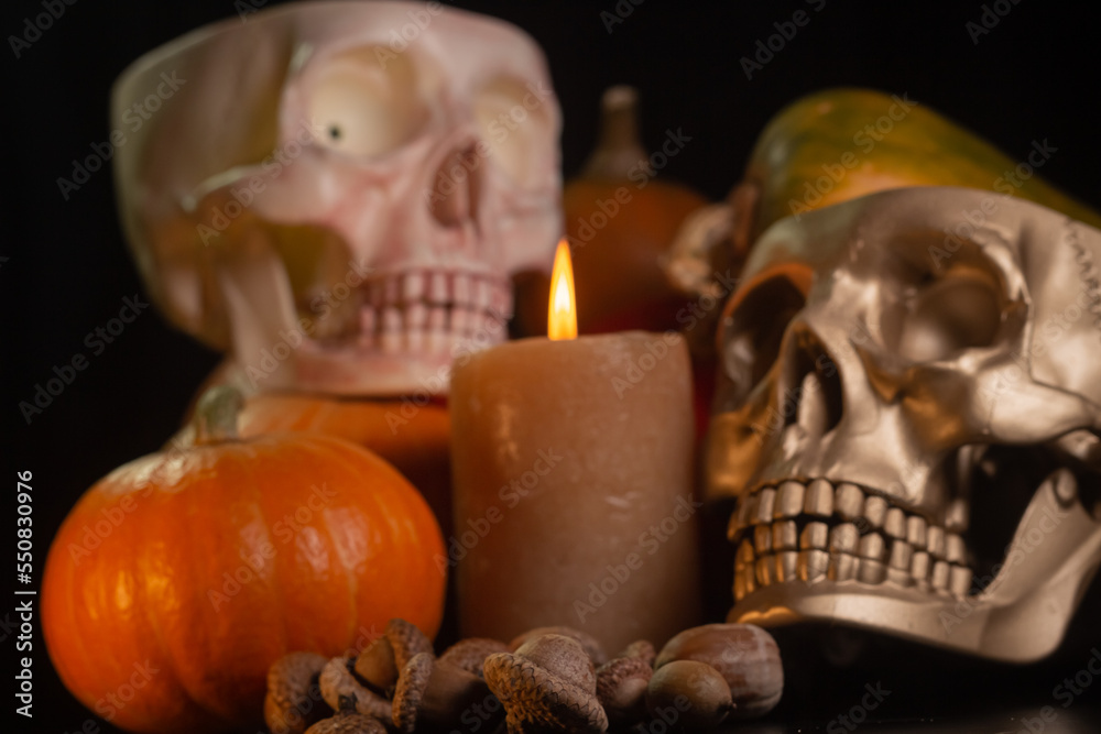 Yellow-orange pumpkins with candles and skulls on a black background the concept of Halloween and the autumn harvest of pumpkin close-up copyspace from above Yellow-orange pumpkins with candles and skulls on a black background the concept of Halloween and the autumn harvest of pumpkin close-up copyspace from above