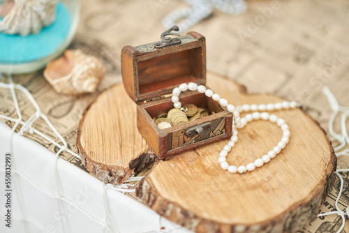 decorative pirate chest with mother-of-pearl necklaces and jewelry, close-up. Pearl jewelry - earrings, bracelet and pearl beads in an antique casket.