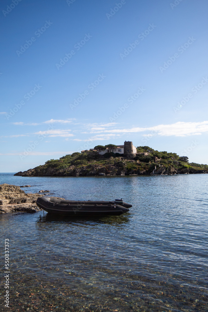 Lancha motora atada a las rocas sobre el mar del pueblo de Cadaqués con una pequeña isla de fondo con mucha naturaleza. Lancha motora atada a las rocas sobre el mar del pueblo de Cadaqués con una pequeña isla de fondo con mucha naturaleza.