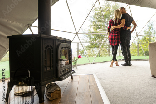 a couple in geo dome tents. Cozy, camping, glamping, holiday, vacation lifestyle concept. Outdoors cabin, scenic background.