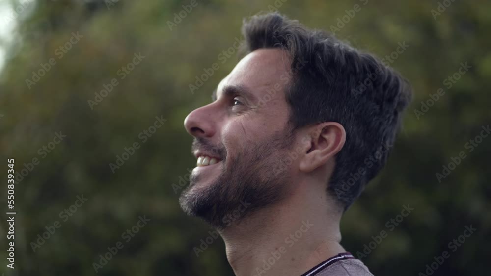Happy person looking at sky smiling. Man standing outdoors closeup face Happy person looking at sky smiling. Man standing outdoors closeup face