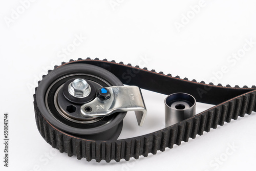 Repair kit: Timing belt with rollers, Tensioner pulley, Deflection pulley, Two rollers, Water pump and bolts on white background. Automobile spare part