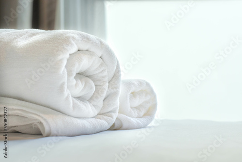 Obraz na płótnie Roll up white towel on bed with copy space on blurred bedroom background by window. w salonie