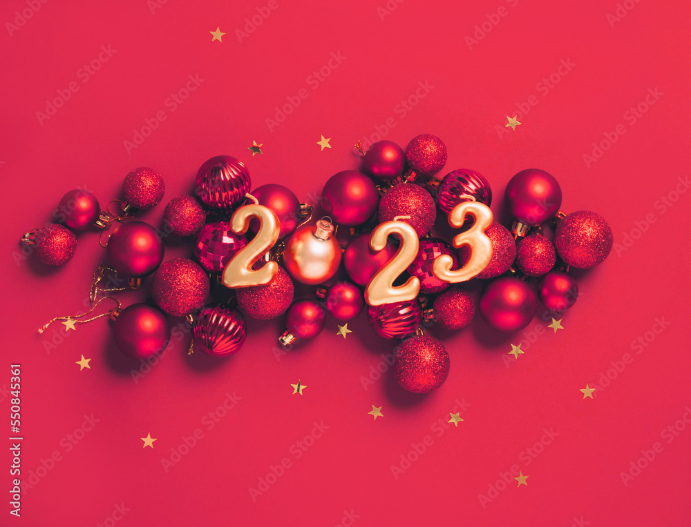 Date 2023 red background of Christmas toys, balls sparkles. Beautiful festive New Year's mockup - obrazy, fototapety, plakaty 