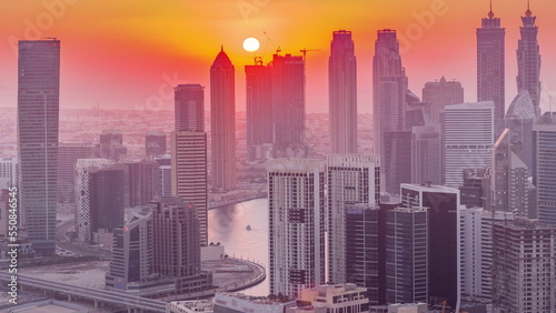 Skyline with modern architecture of Dubai business bay towers at sunset timelapse. Aerial view