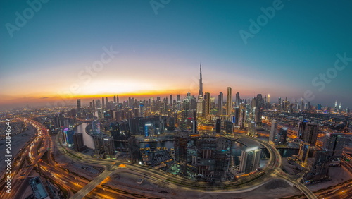 Panoramic skyline of Dubai with business bay and downtown district day to night timelapse. photo