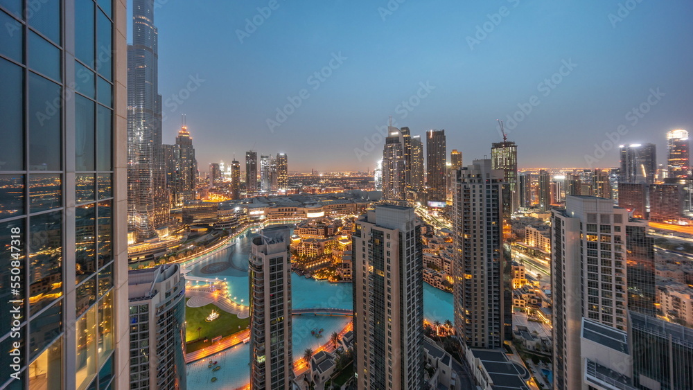 Obraz premium Dubai downtown with fountains and modern futuristic architecture aerial night to day timelapse