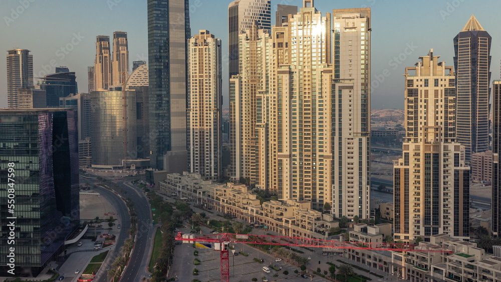 Naklejka premium Bay Avenue during sunrise with modern towers in Business Bay aerial timelapse, Dubai