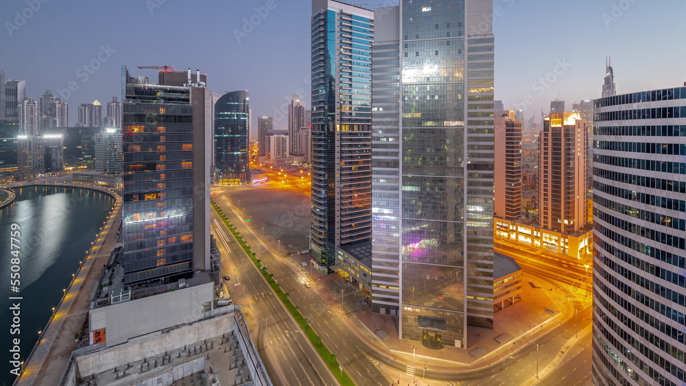 Obraz premium Cityscape of skyscrapers in Dubai Business Bay with water canal aerial night to day timelapse