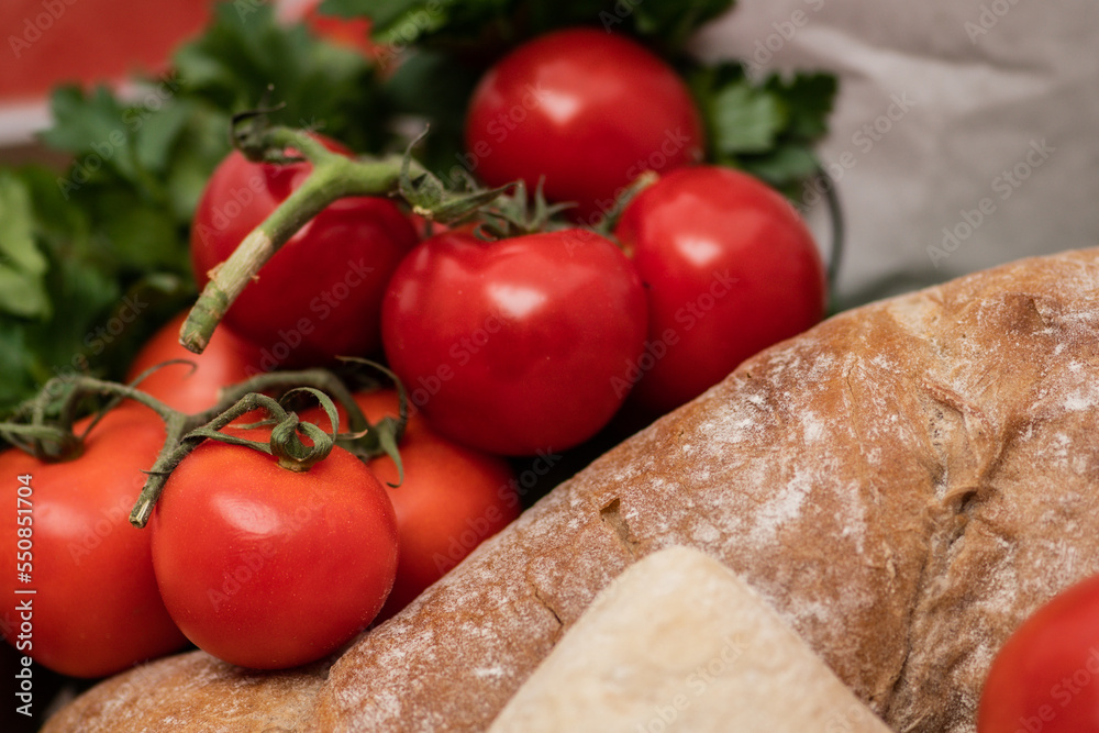 Fresh bio ripe red tomatoes with white bread, parsley leaves in a wooden box in a street food market, close up Fresh bio ripe red tomatoes with white bread, parsley leaves in a wooden box in a street food market, close up
