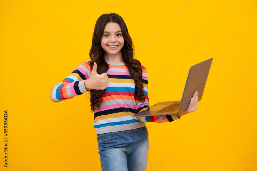 Young girl student hold computer. Funny pupil with laptop isolated on yellow background. Back to school. Happy teenager, positive and smiling emotions of teen schoolgirl. Young girl student hold computer. Funny pupil with laptop isolated on yellow background. Back to school. Happy teenager, positive and smiling emotions of teen schoolgirl.