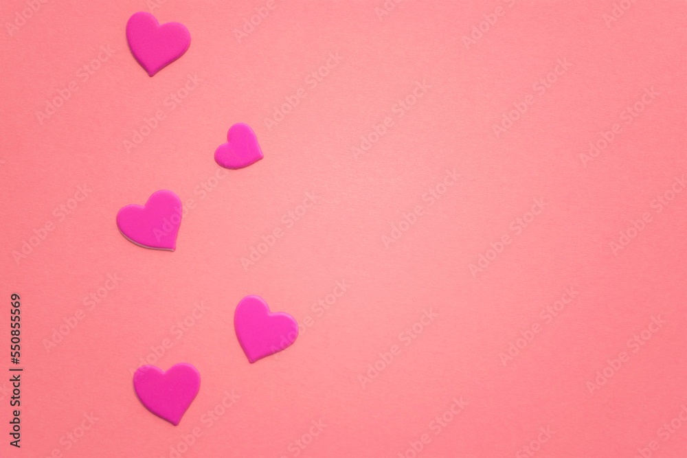 Lovely magenta hearts on pink paper table. Copy space.