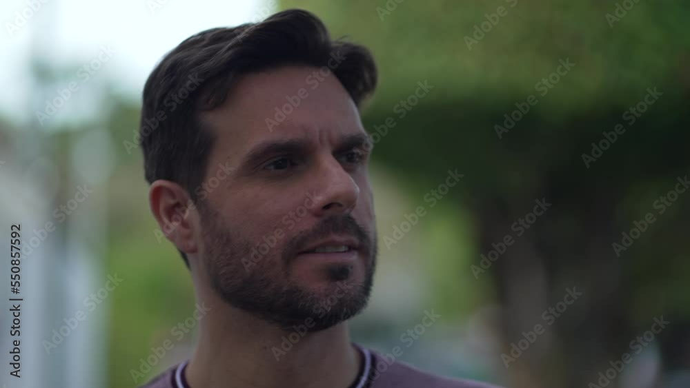 Portrait of a pensive young man walking forward outside. A contemplative thoughtful person face closeup Portrait of a pensive young man walking forward outside. A contemplative thoughtful person face closeup