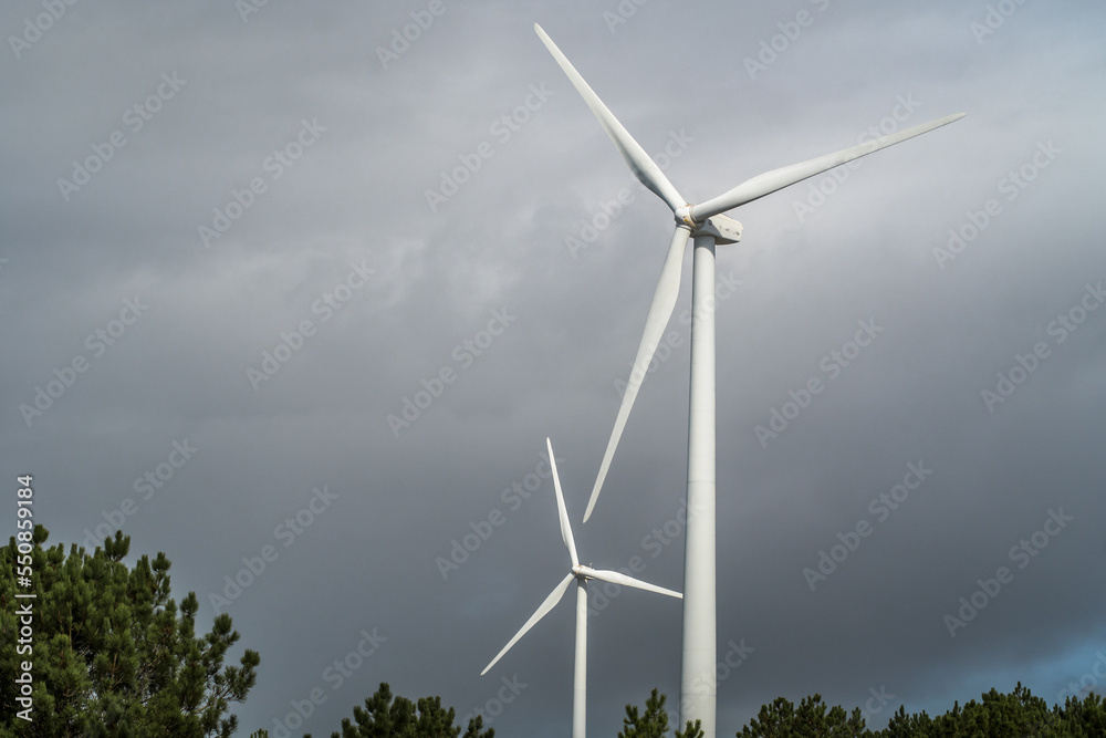 Fototapeta premium Wind turbines against the cloudy sky. Wind power plant