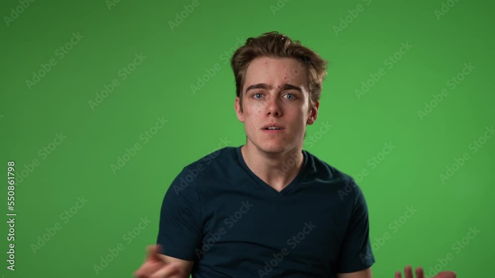 Portrait of hipster man 20s looks around put finger to lips shh quiet isolated on green screen background studio in slow motion