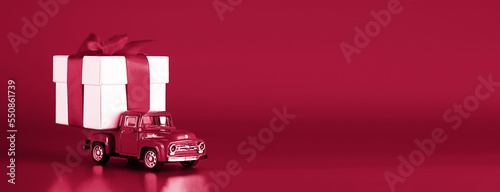 Fototapeta Naklejka Na Ścianę i Meble -  Red car with a gift box on a red background. Concept - delivery of gifts for the holidays, Valentine's Day, International Women's Day, February 14, March 8. Shopping, sale