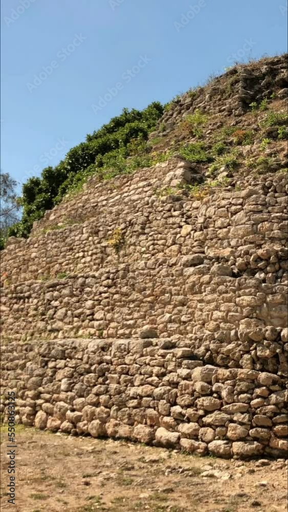Panning, close up shot of the ruins of a Mayan temple in a village in Mexico, vertical video
