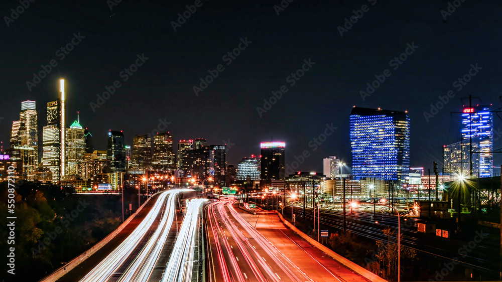 Skyline of Philadelphia (PA) USA at night with car trails on a expressway, with copy space.