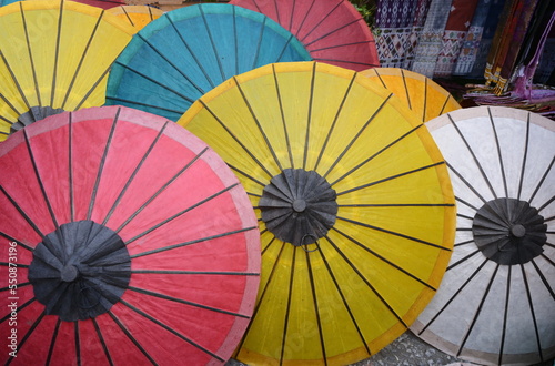 Colorful mulberry paper umbrellas are sold at souvenir shops. White, yellow, red, orange, blue handmade umbrellas made from dyed mulberry paper are used to protect the sun and decorate the place. 