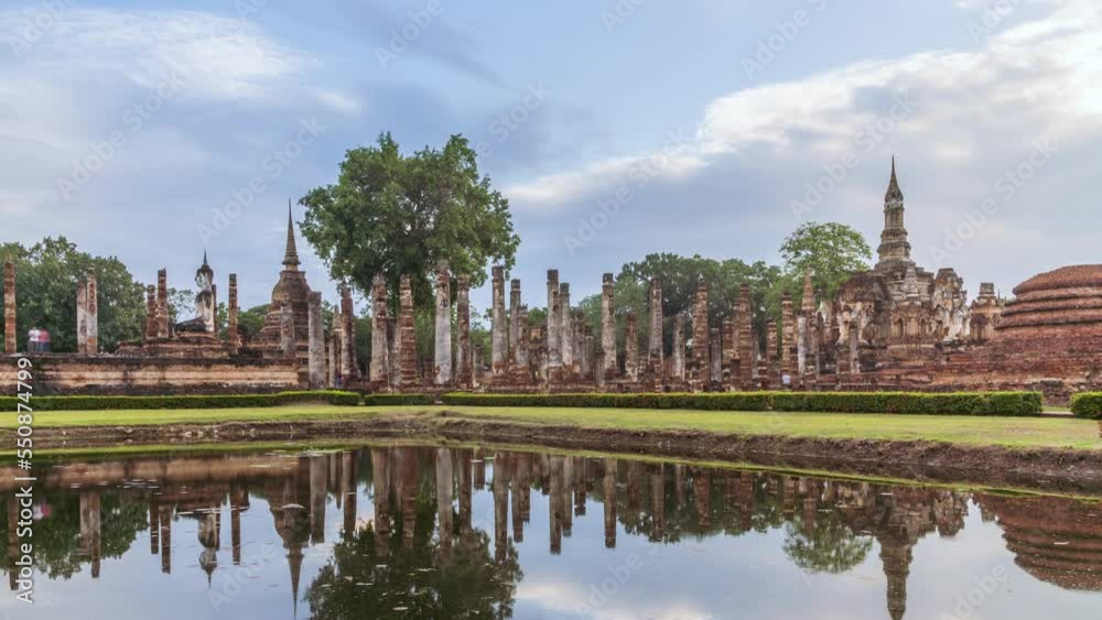 Buddha statue and pagoda Wat Mahathat temple with reflection, Sukhothai Historical Park, Thailand - Time Lapse Buddha statue and pagoda Wat Mahathat temple with reflection, Sukhothai Historical Park, Thailand - Time Lapse