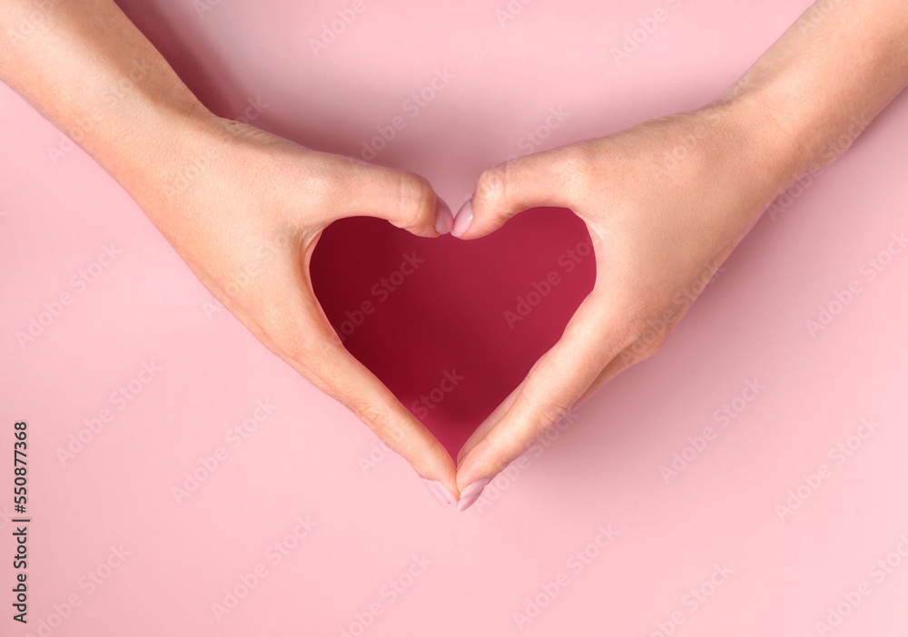 Obraz premium Demonstrating color of 2023 Viva Magenta. Female hands making heart. Love, friendship, peace concept. Valentine day, Birthday, Mothers Day.