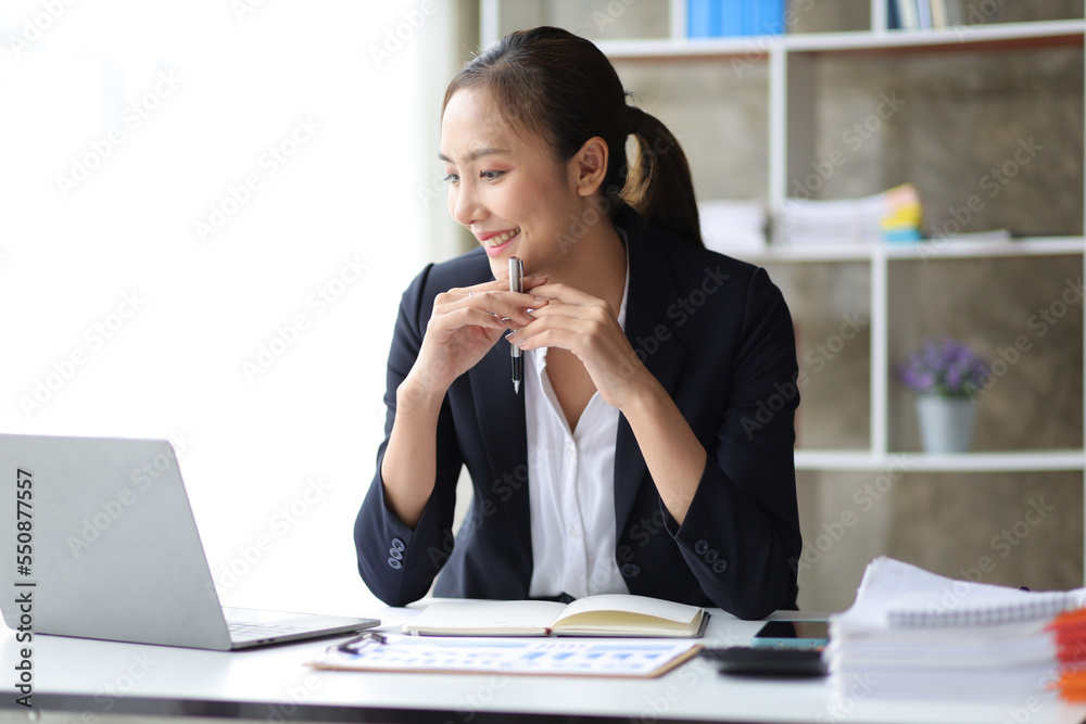 Portrait of charming business woman in office working on laptop and business report papers. Portrait of charming business woman in office working on laptop and business report papers.