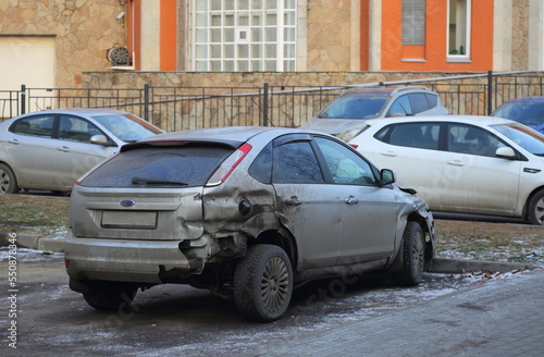 A broken gray car is parked on the street, Kollontai Street, St. Petersburg, Russia, December 2022