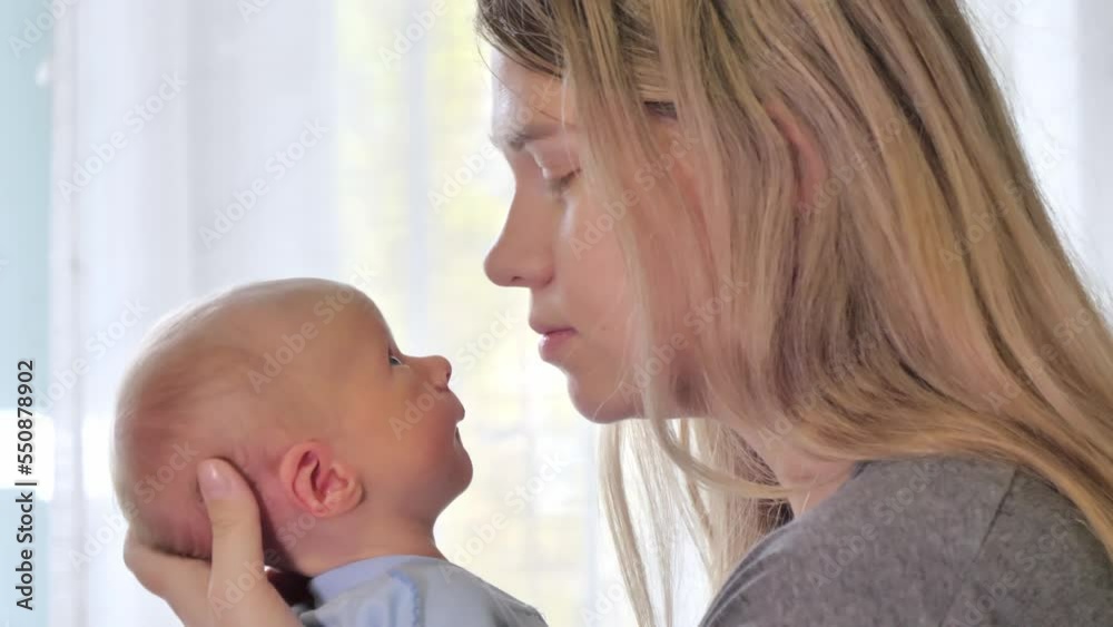 Mom kissing her newborn baby. Love and tenderness. Family concept. Slow motion shot Mom kissing her newborn baby. Love and tenderness. Family concept. Slow motion shot