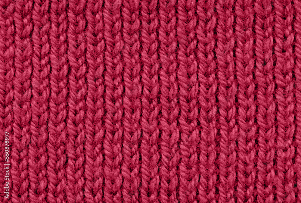 Texture of knitted handmade. Close up. Wallpaper or abstract background. Pattern. Trending color of 2023 - Viva Magenta.