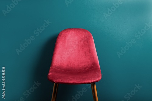 Modern Velour Chair Viva Magenta, color of the year 2023 on wooden legs, blue background