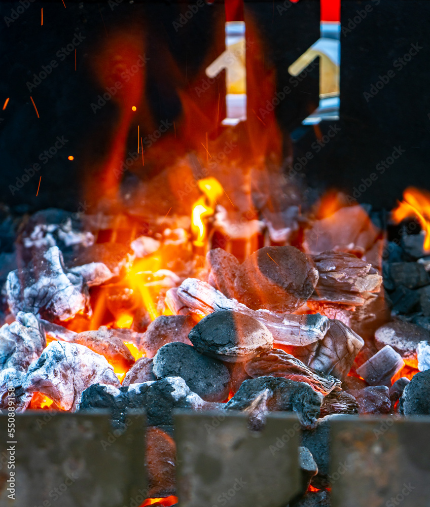 Charcoal and embers burning at full capacity at its peak in a metal barbecue and smoke Charcoal and embers burning at full capacity at its peak in a metal barbecue and smoke
