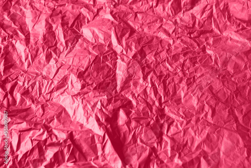 Crumpled paper Viva Magenta color of the year 2023. Texture crumpled paper for your design. Copy space. Viva Magenta color paper.