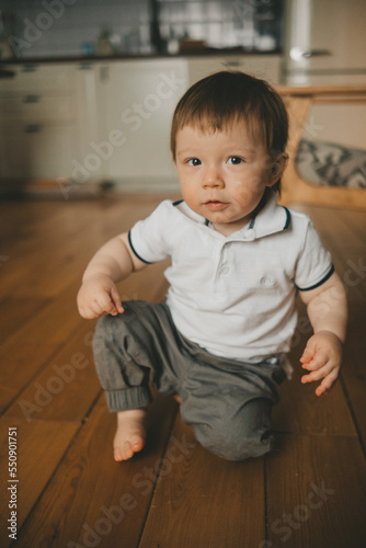 portrait of a smiling baby one year old at home on the floor