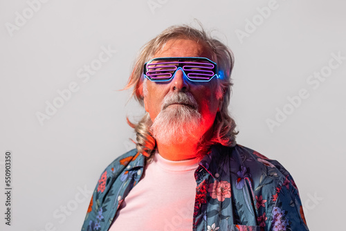 Senior male in led rave glasses in studio photo