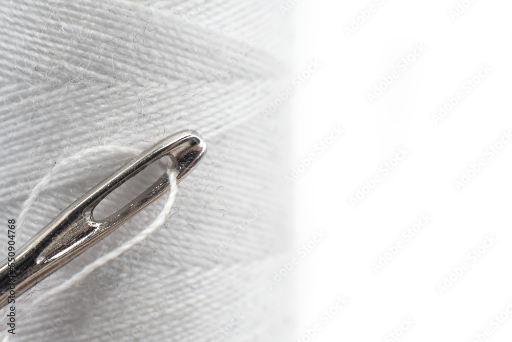 Needle and thread on a white background close-up. Needle isolate with empty space for inscription Needle and thread on a white background close-up. Needle isolate with empty space for inscription