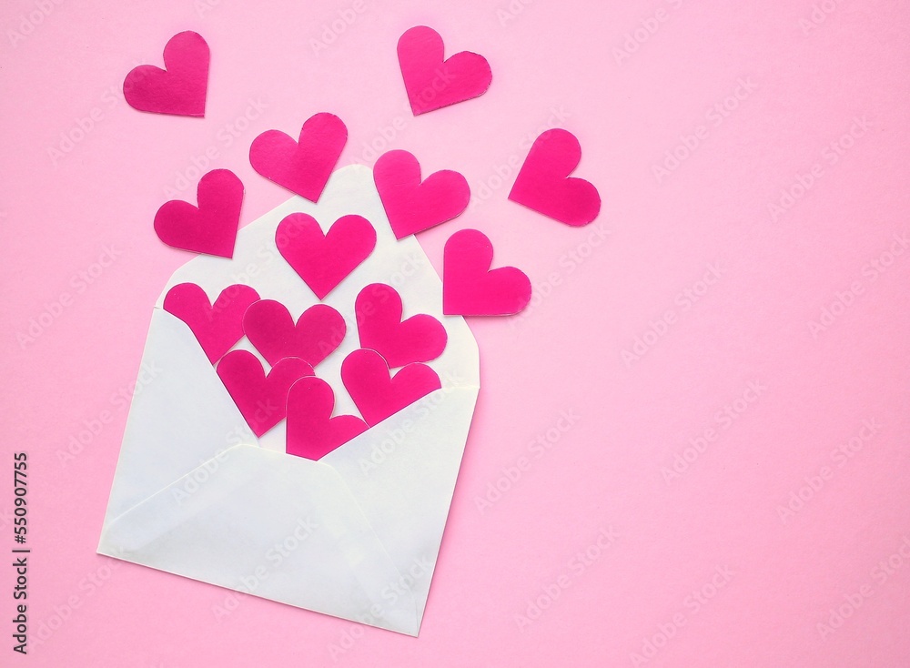 Pink hearts and white envelope on pink background. Romantic message, letter, gift, greeting card for Valentine's Day concept. Holiday festive creative design love composition. Flatlay, top view