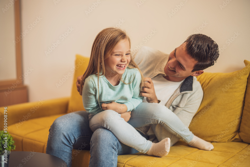 Happy father and daughter enjoy spending time together at their home.