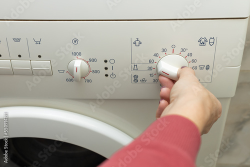 A person chooses a washing mode with a switch.