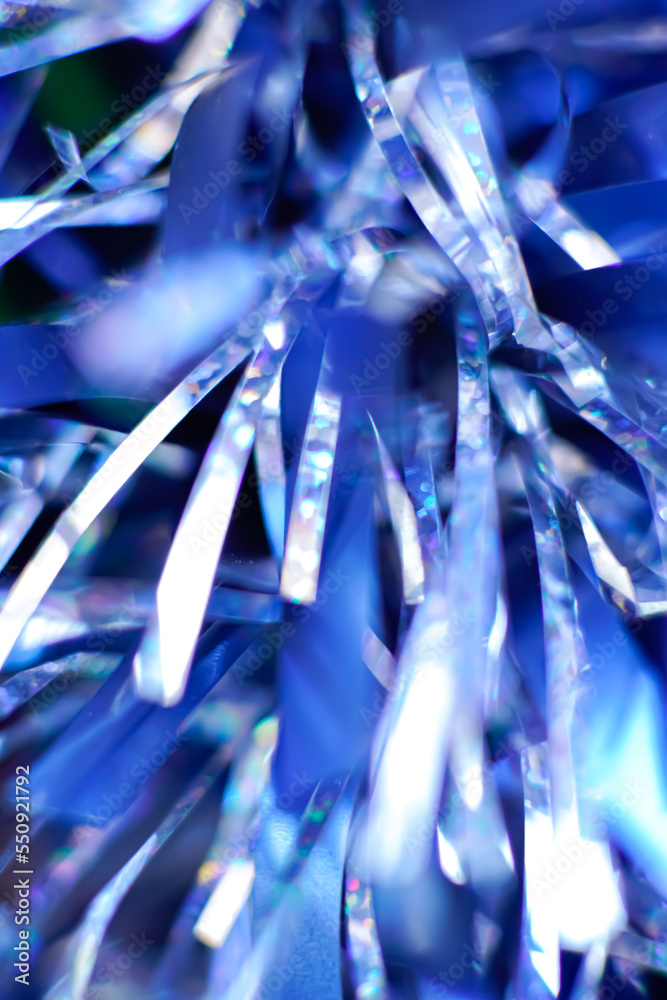 Bluish and shiny tinsel in the foreground. Festive carnival and christmas background Bluish and shiny tinsel in the foreground. Festive carnival and christmas background